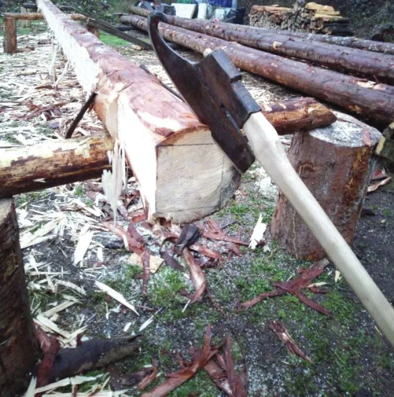 L'outil de travail du charpentier : une hache affûtée, forgée sur-mesure.